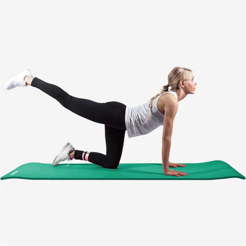 En kvinna som stretchar på en grön träningsmatta från gorilla sports
