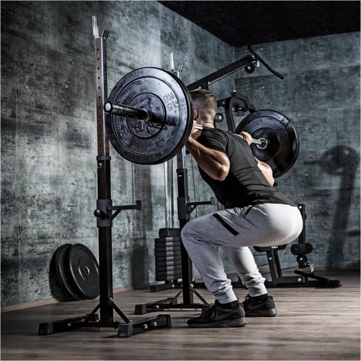 Man som tränar med en skivstång och ett skivstångsställ från Gorilla Spots